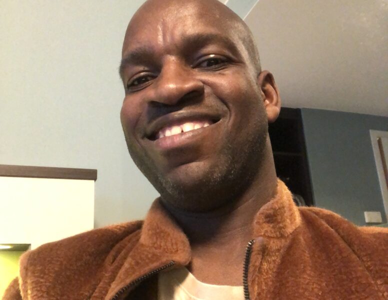 Image: Edmore Masendeke, Author. Close-up shot of Edmore, a Black man, smiling at the camera.